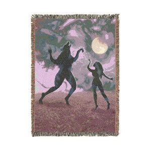 Woven blanket in purple hues design featuring a person and wolf dancing under the moon.